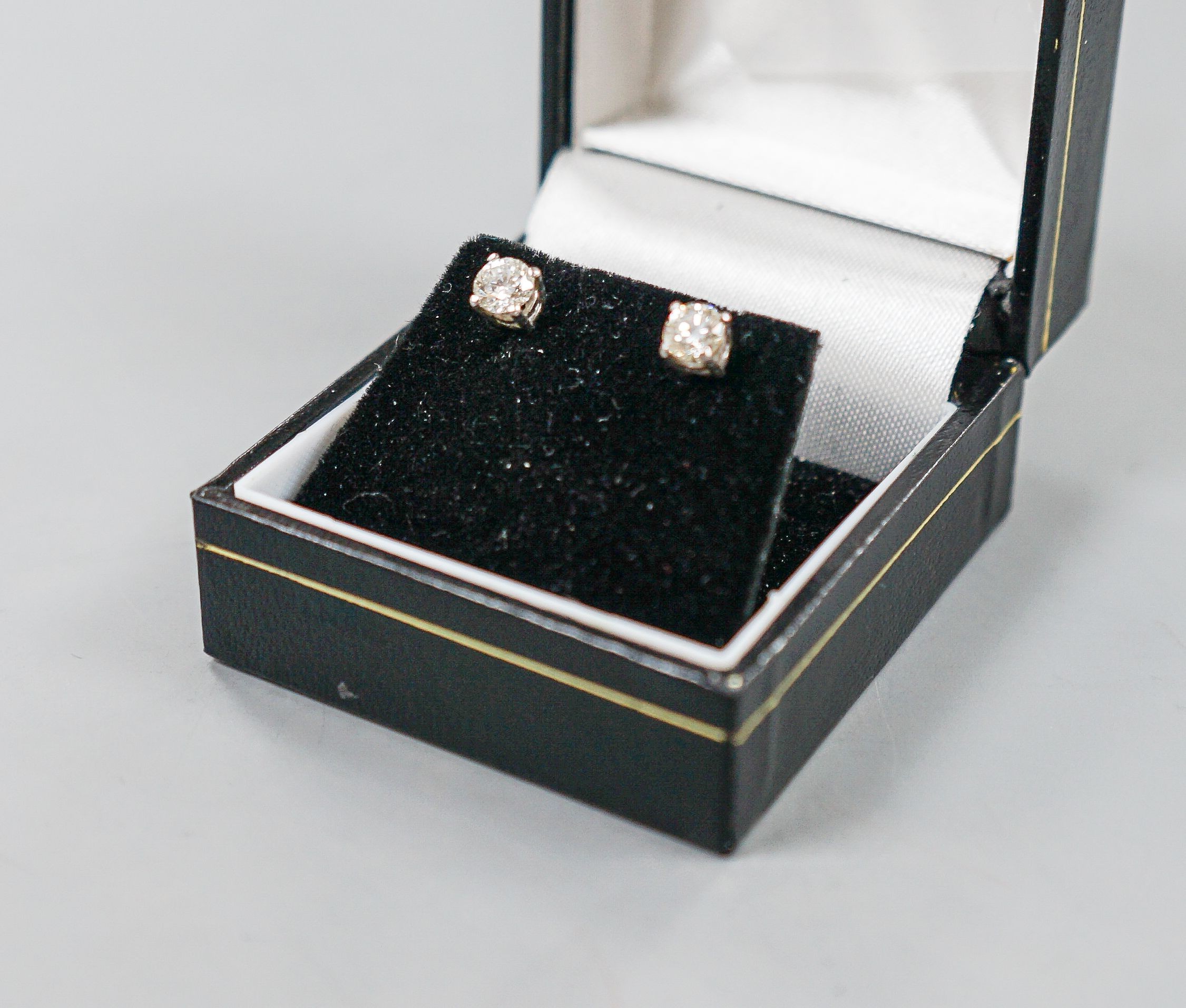 A pair of 750 white metal and solitaire diamond ear studs, gross weight 1.8 grams